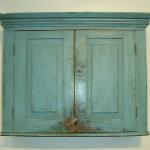 This early 19th Century New England blue painted hanging wall cupboard has double raised panel doors & applied cornice molding.
31”H x 7 ½”D x 26 ½”H